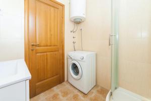 a bathroom with a washing machine next to a door at Апартаменты в Каменари in Kamenari +4 photos