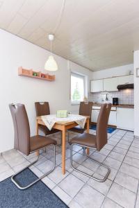 una cucina e una sala da pranzo con tavolo e sedie di Seekieker - Nordseewelle a Esens