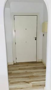 an empty room with a white door and a wooden floor at Piso reformado en Murcia con terraza in Murcia