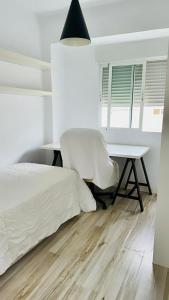 a bedroom with a bed and a desk and a chair at Piso reformado en Murcia con terraza in Murcia