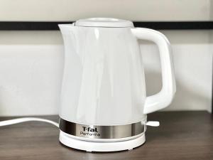 a white coffee pot sitting on top of a table at Shinjuku-STS Hostel in Tokyo