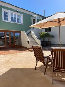 a patio with two chairs and an umbrella at Santa Eulalia in Lugo