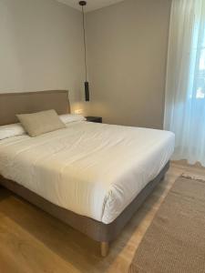 a bedroom with a large bed with a white comforter at Santa Eulalia in Lugo