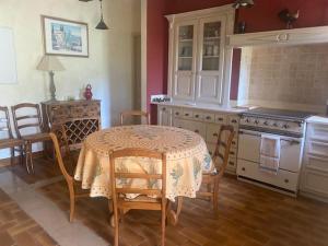 a kitchen with a table and a table and chairs at La Maison Vieille in Peillon +12 photos