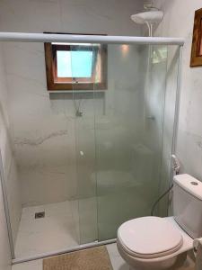 e bagno con servizi igienici e doccia in vetro. di Chalé verde - Moreré a Moreré