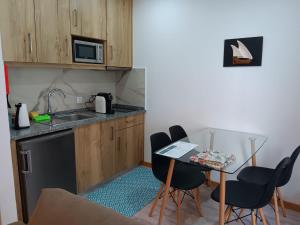 a kitchen with a table and chairs and a sink at Casa Bateira in Figueira da Foz