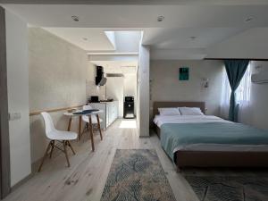 布什泰尼La Casa Verde的一间带床、桌子的卧室和一间厨房