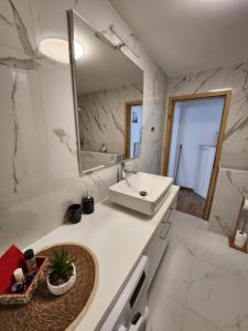a white bathroom with a sink and a mirror at Apartma Aleksandra in Sečovlje
