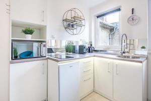 a kitchen with white cabinets and a sink and a window at Castle View - NEW - Romantic in Budapest