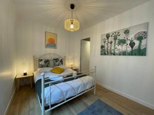 ルーアンにあるL'Escale de Saint Maclou-Rouen centre Historiqueのベッドとシャンデリアのある寝室