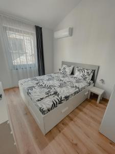 une chambre avec un lit dans une pièce blanche dans l'établissement Hugo, à Varna