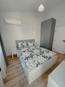 une chambre avec un lit dans une pièce blanche dans l'établissement Hugo, à Varna