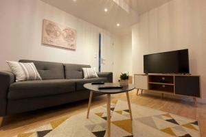 ルーアンにあるL'Escale de Saint Maclou-Rouen centre Historiqueのソファとテーブルとテレビのあるリビングルーム