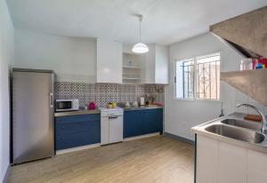 een keuken met blauwe kasten en een wastafel bij Apartamento Sierra Nevada Viva in Otura