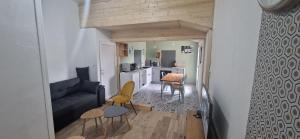 un soggiorno con divano e una cucina di Le Tillois a Tilly-sur-Seulles