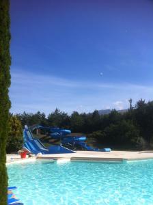 a large swimming pool with a water slide at Chalet Le Fario, Bain nordique in Fréchet-Aure