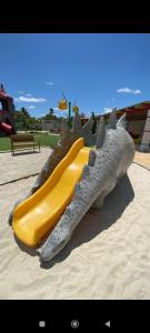 a slide in the shape of a dinosaur on a playground at Apartamento Aconchego condomínio florida in Feira de Santana