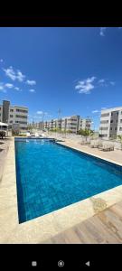 Apartamento Aconchego condomínio florida في فييرا دي سانتانا: مسبح ازرق كبير امام مبنى