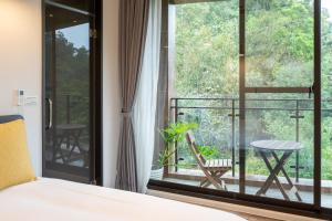 - une chambre avec un lit et une vue sur un balcon dans l'établissement Siang Tsao Yu Chong, à Sanyi