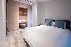 1 dormitorio con 1 cama blanca grande con almohadas azules en Siang Tsao Yu Chong, en Sanyi