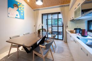 cocina y comedor con mesa de madera y sillas en Siang Tsao Yu Chong, en Sanyi