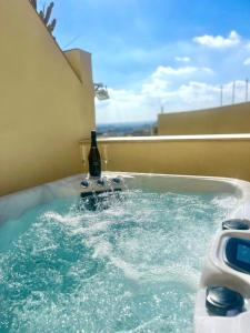 een hot tub met een fles wijn en 2 glazen bij Marea Boutique Hotels in Sliema