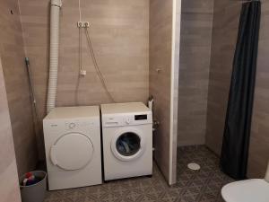 a washing machine in a bathroom with a washer at Sentrumsnær overnatting in Alta