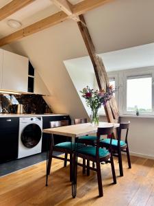 una cucina con tavolo e sedie in legno e una cucina con soffitto di Meadowview Unique private apartment near city centre ad Amsterdam