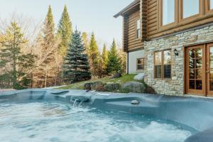 a hot tub in front of a house at Fiddler Lake Resort Chalet 87 Deer in Mille-Isles