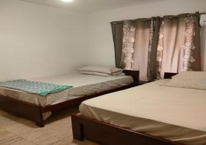 a room with two beds and a window with curtains at Blumar Sidi Abdel Rahman 2 bedrooms Chalet North Coast in El Alamein +97 photos
