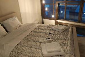 uma cama grande com duas toalhas em cima em Karditsa's Loft House em Karditsa