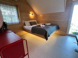 a bedroom with a bed in a wooden cabin at NEON Apartman Csopak Balaton in Csopak