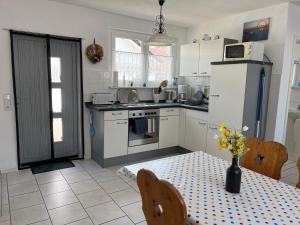 a kitchen with a table with a vase of flowers on it at Ferienhaus Schmidt in Storkow +11 photos