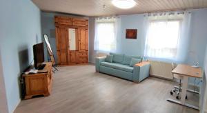 a living room with a blue couch and a television at Gemütliches Gästehaus am Park in Rastatt