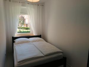 Bett in einem Zimmer mit Fenster in der Unterkunft Apartament u Przewodnika Sudeckiego in Duszniki-Zdrój