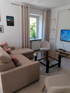 ein Wohnzimmer mit einem Sofa und einem Tisch in der Unterkunft Apartament u Przewodnika Sudeckiego in Duszniki-Zdrój