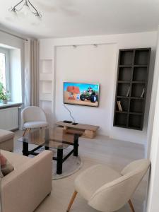 ein Wohnzimmer mit einem Sofa und einem Tisch in der Unterkunft Apartament u Przewodnika Sudeckiego in Duszniki-Zdrój