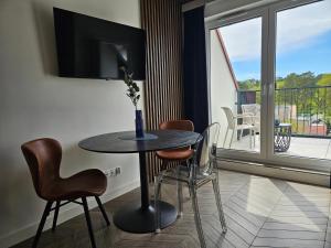 a table and chairs in a room with a balcony at Horizon Vista - New - Premium - Parking in Świnoujście