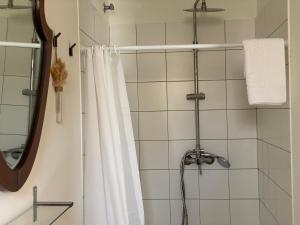 a shower with a white shower curtain and a mirror at Les Filles (antiga Fonda de la Parra) in Deltebre