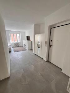 een lege woonkamer met een grote witte deur bij Appartamento The Twins in Asti