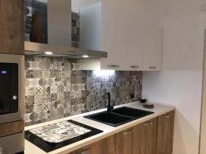 a kitchen with a sink and a counter top at Appartamento Pine relaxing house in Pinerolo