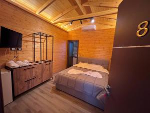 um quarto com uma cama e uma televisão num quarto em HOTEL MEGNIAR em Lushnjë
