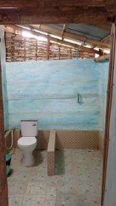 ein Bad mit einem WC und einer blauen Wand in der Unterkunft OBT - The Jack Fruit Bungalow 
