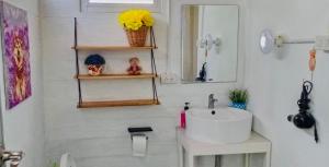 Baño blanco con lavabo y espejo en P Mee Home, 