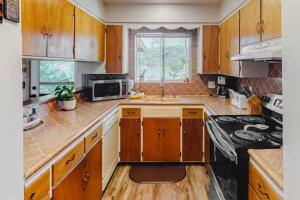 a kitchen with wooden cabinets and a sink and a stove at Fox Lakeview Home in Bass Lake