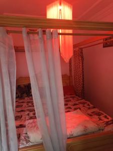a bunk bed with white curtains in a room at Le petit VIP in 'Aïn el Turk