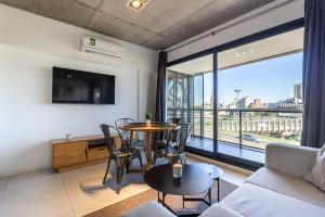 a living room with a table and chairs and a large window at Loft Elegante a 5 Minutos de Puerto Madero 6B in Buenos Aires