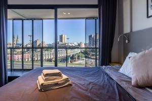 - un lit avec serviettes dans une chambre avec fenêtre dans l'établissement Loft Elegante a 5 Minutos de Puerto Madero 6B, à Buenos Aires