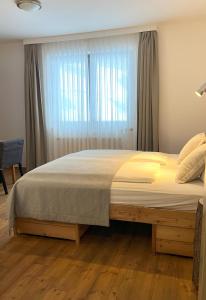 a bedroom with a large bed with a window at Heimat - Das Natur Resort in Prägraten am Großvenediger