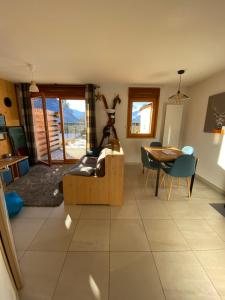 a living room with a table and a dining room at C03 lajoue in Le Dévoluy